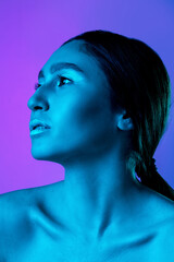 Fototapeta premium Dreams. Beautiful east woman's portrait isolated on gradient studio background in neon, monochrome. Female brunette model. Concept of human emotions, facial expression, sales, ad, fashion and beauty.