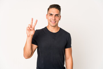 Young caucasian handsome man isolated showing victory sign and smiling broadly.