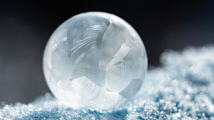 frozen bubble with bokeh background. Beautiful frosty patterns on frozen soap bubble. winter, frosty background. Macro photo