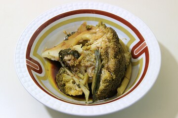 Freshly cooked green broccoli salad, olive oil and vinegar in a plate isolated on white background. Closeup, selective focus