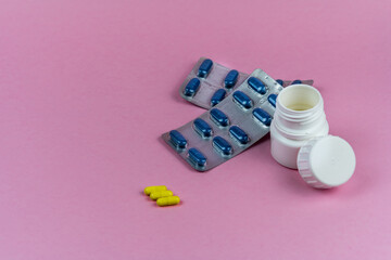 pill bottle on a pink background with drug blisters