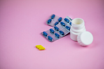 pill bottle on a pink background with drug blisters