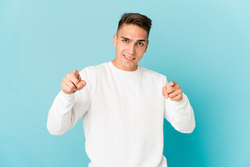 Young caucasian handsome man isolated pointing to front with fingers.