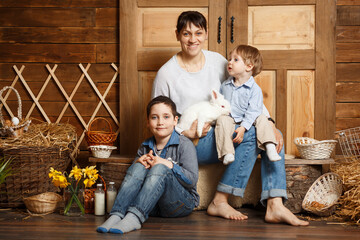 Mother and sons in the village. Happy weeekend. Easter preparations. Holiday. Excited little boys and female spending Easter day at family farm. Family in rural wooden interior with flowers in studio.