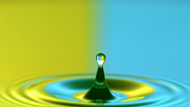 Close-up of a water droplet falling in water in super slow motion, yellow and blue colors