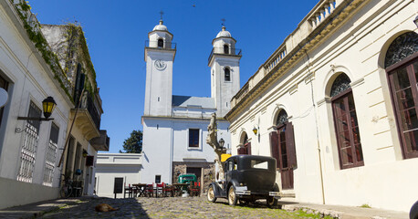 Obsolete cars, in front of the church of Colonia del Sacramento, Uruguay. It is one of the oldest...