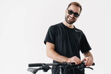 Happy young rider man smiling while posing with his bicycle
