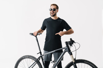 Happy young rider man pointing finger at his bicycle saddle