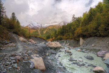 Fototapeta na wymiar The mountain river flows through the mountain valley. Natural landscape with mountains.