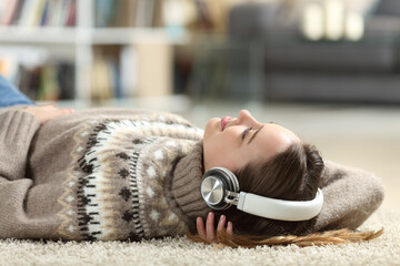 Relaxed teen listening to music at home in winter