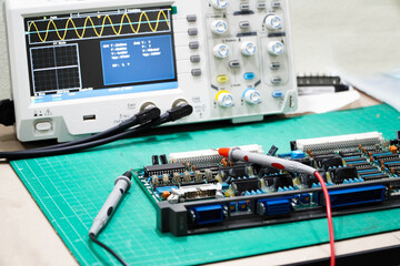 technician is inspecting the circuit board by digital storage oscilloscope