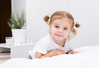 portrait of toddler blond girl with two tails at home