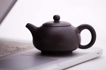 A teapot on the computer keyboard,close-up