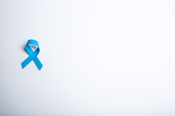 Blue handmade awareness paper ribbon on white background.