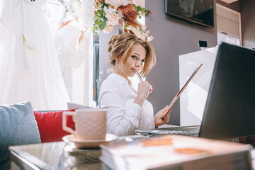 young woman wedding planner in office with laptop and tablet for writing