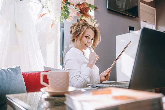 Young Woman Wedding Planner In Office With Laptop And Tablet For Writing