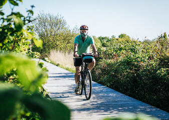 Senior man with face mask on bike