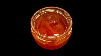 Jelly in a glass jar isolated on a black background.