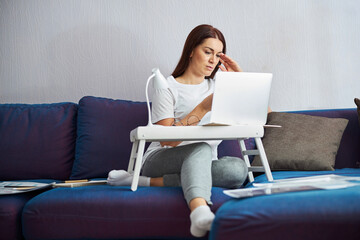 Fototapeta na wymiar Attractive woman working online in living room