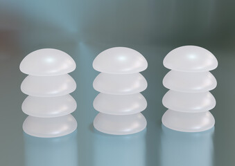 Silicone breast implant stacked on a stainless steel table