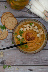 Vegan cream soup made with roasted pumpkin, carrot and tomato, topped with croutons, copy space
