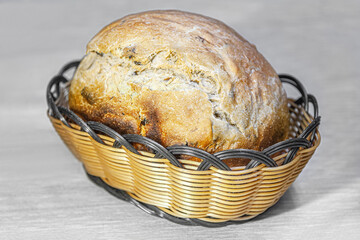 sweet bread with dried fruits in a basket baked in a home bread machine close up