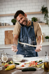 Attractive man cooking in modern kitchen. Handsome man talking to the phone while cooking..