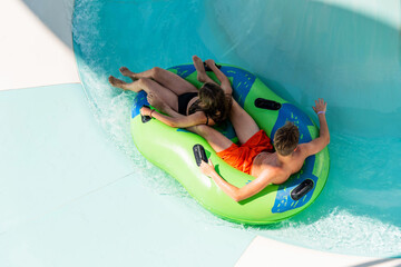 Girl and boy in water Park. Fun on the water. Teen girl and boy having fun in the water slider ....
