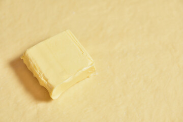 Piece of butter is on the raw dough