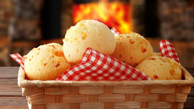 homemade cheese bread, traditional Brazilian snack, in the basket after leaving the oven on a rustic kitchen table