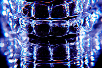 Invisible dental teeth brackets tooth aligners on black background. Plastic braces dentistry...