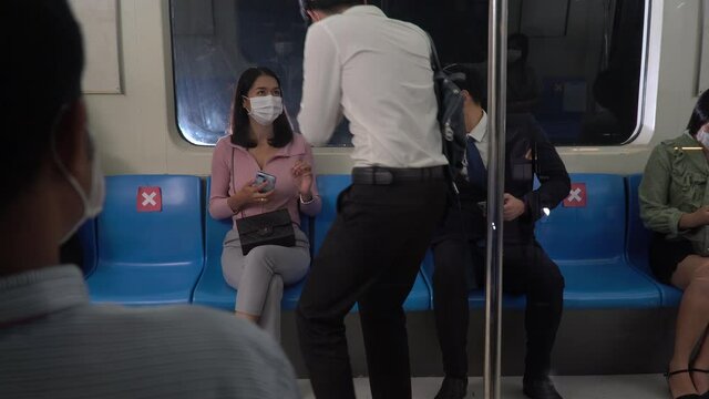 Stop not sitting to the next each  seat keep social distancing in public transportation. asian passenger wearing surgical face mask sitting in subway. new normal in Coronavirus or Covid-19 pandemic