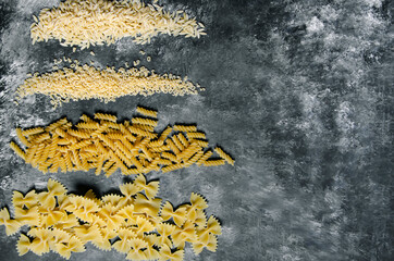 on black and white ground, auger pasta, pipe pasta, spaghetti, bow tie pasta