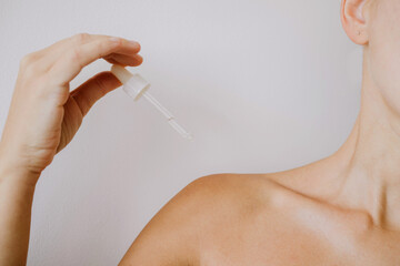 Woman holding a bottle with the skin serum