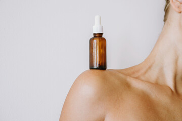 Woman holding a bottle with the skin serum