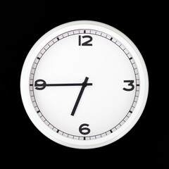 White round analog wall clock isolated on black background.