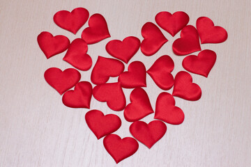 The heart is made of decorative hearts on a wooden surface. Valentine's Day decoration. The photo