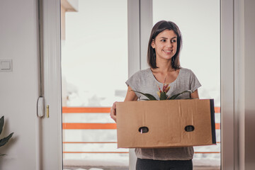 Moving into new apartment . Beautiful young woman with boxes in new home