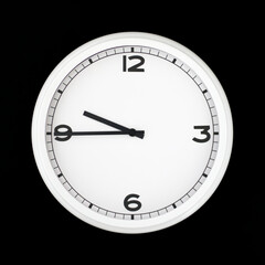 White round analog wall clock isolated on black background.
