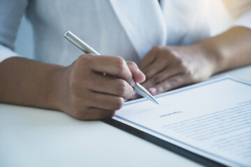 woman hand signing on business contract papers in home office