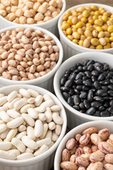 Closeup of assorted beans on white bowls