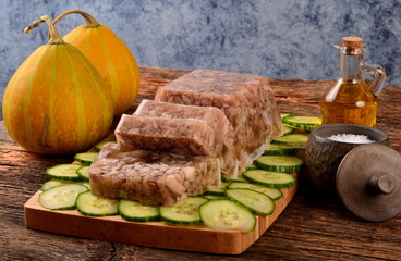 Meat jelly or brawn on a plate. Homemade head cheese on cucumber slices