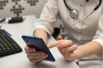 Medical technology concept. Doctor working with mobile phone and stethoscope in modern office at hospital.