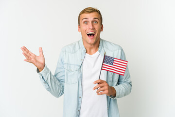 Young caucasian man holding a american flag isolated on white background