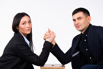 Business partners are competing and looking at the camera. Arm wrestling on a white background.