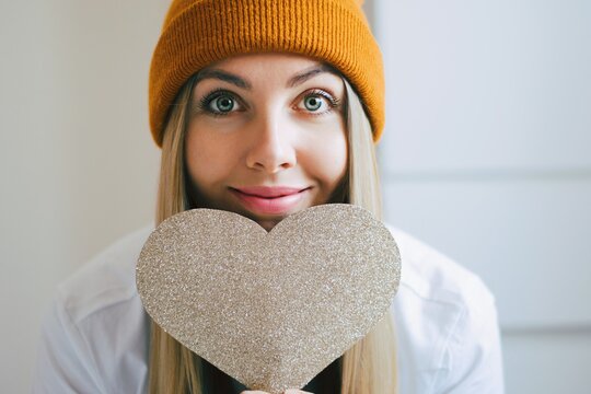 Pretty hipster girl with a big paper heart on the hands. Portrait of smailing girl ready for Snt. Valentines day. Cupid day. Love