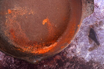 Rusty metal pans on a rustic background. Renovation of cast iron pan. Old rusty round cast iron...