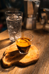 Espresso coffee is flowing into the shot cup.