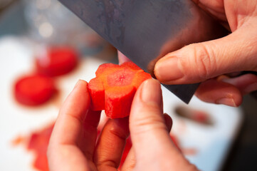 にんじんを切ってねじり梅を作る女性の手 梅にんじん 包丁で切る 和食 日本 