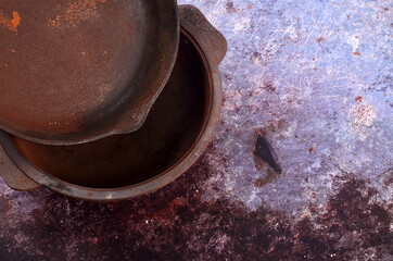 Rusty metal pans on a rustic background. Renovation of cast iron pan. Old rusty round cast iron...